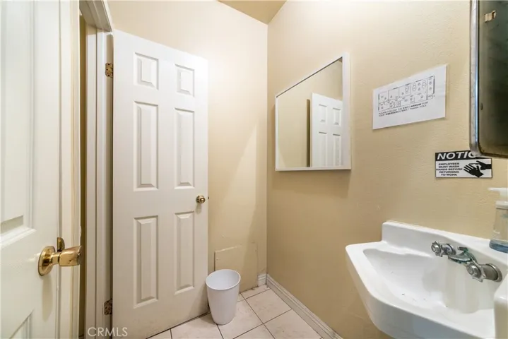 13175 Paramount Blvd bathroom with a sink and two toilet private rooms.