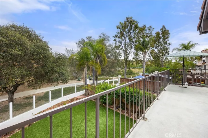 SECOND STORY BALCONY WITH VIEWS OF THE TREES AND WALKING PATH