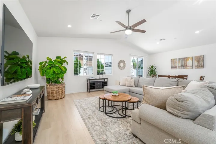 Great room with lighted ceiling fan and expansive windows