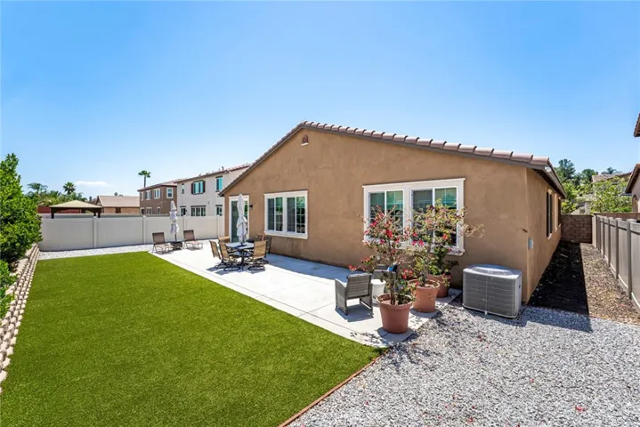 Large yard with artificial turf, raised bed with mature trees