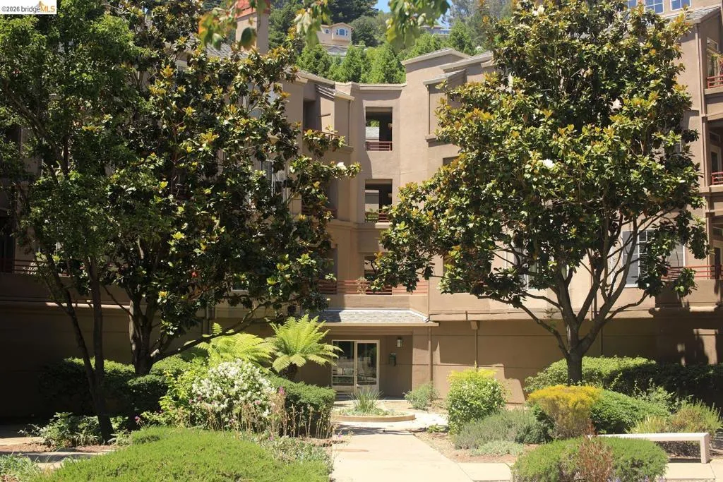 Multi-story stucco building featuring multiple balconies and a ground-level entrance with an overhead canopy - 280 Building