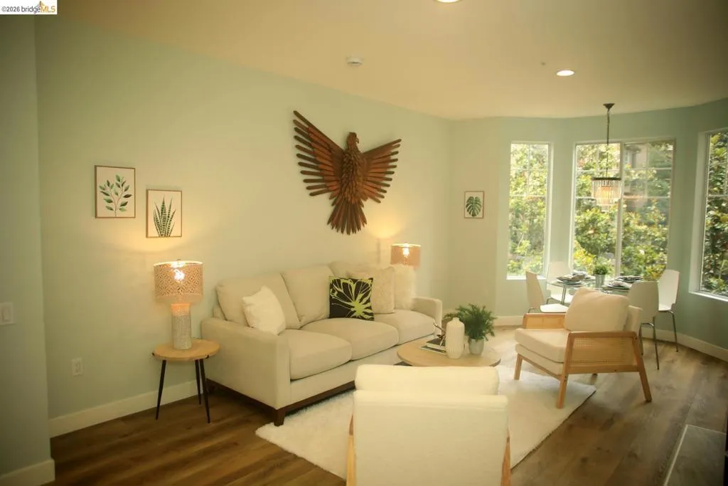 Open concept living and dining area featuring wood-finish flooring, recessed lighting, and a bay window configuration