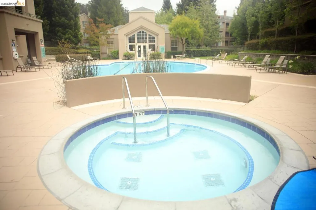 Outdoor spa with blue mosaic tile accents and integrated steps