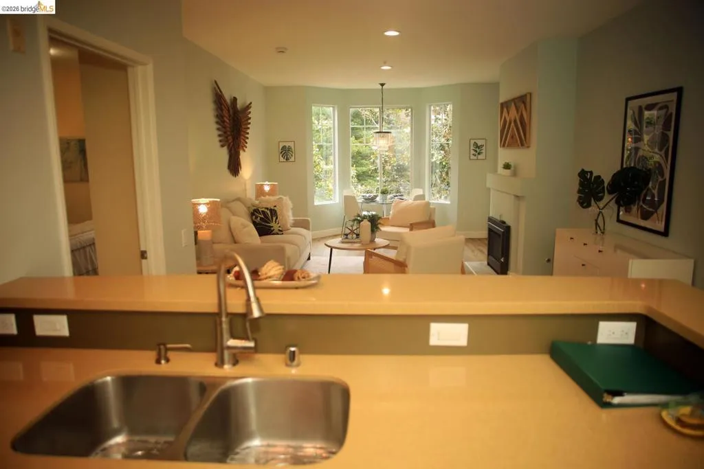 Kitchen peninsula featuring a dual-basin stainless steel sink with a high-arc faucet, complemented by a light-toned countertop