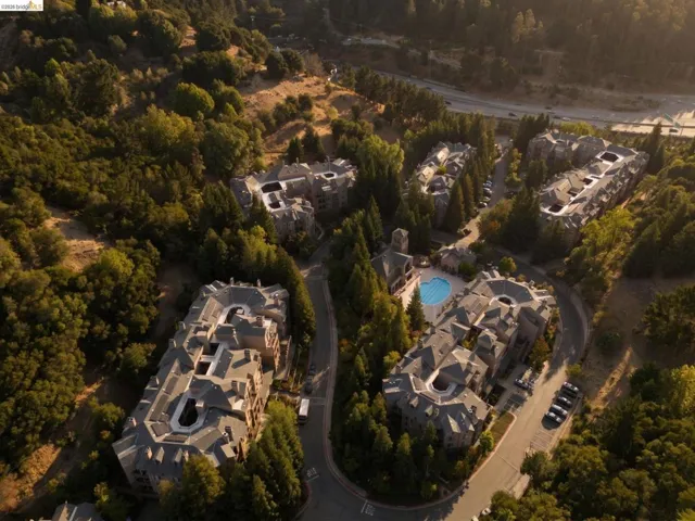Expansive residential complex featuring multiple buildings with intricate rooflines and surrounding mature trees