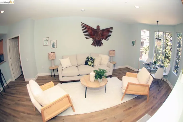 Light-filled living space featuring wood-finish flooring, recessed lighting, and expansive windows