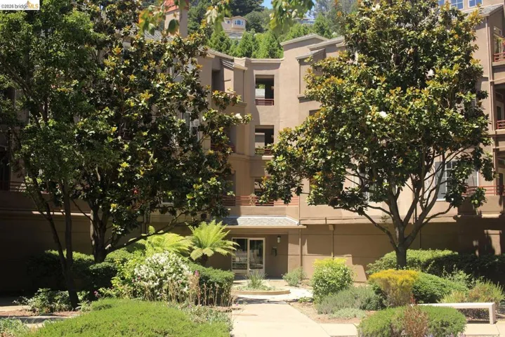 Multi-story stucco building featuring multiple balconies and a ground-level entrance with an overhead canopy - 280 Building