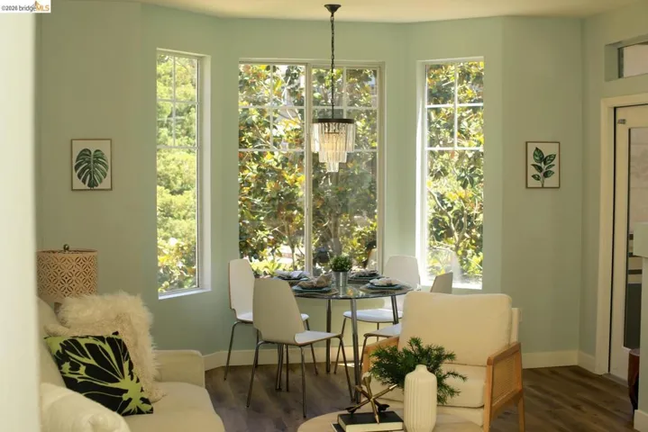 Bay window dining area featuring a contemporary chandelier and wood-finish flooring