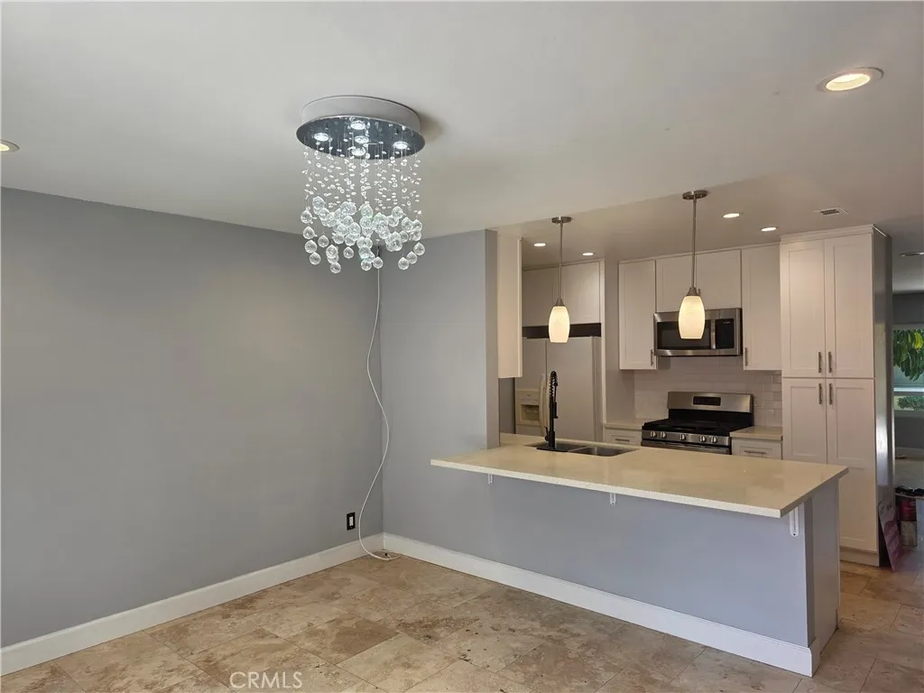 Oversized quartz counter treats a breakfast bar.