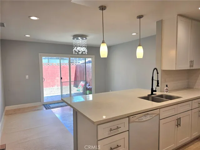 Beautiful remodel.  Recesses lights, crystal chandelier, pendant lighting over quartz breakfast bar.