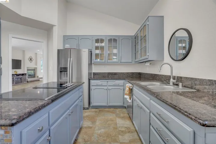 Kitchen featuring light blue cabinetry and dark stone countertops