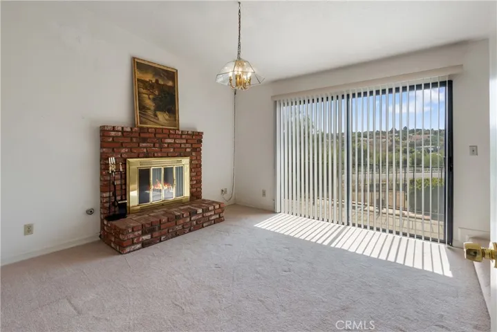 Primary bedroom with gas fireplace and sliding door to balcony