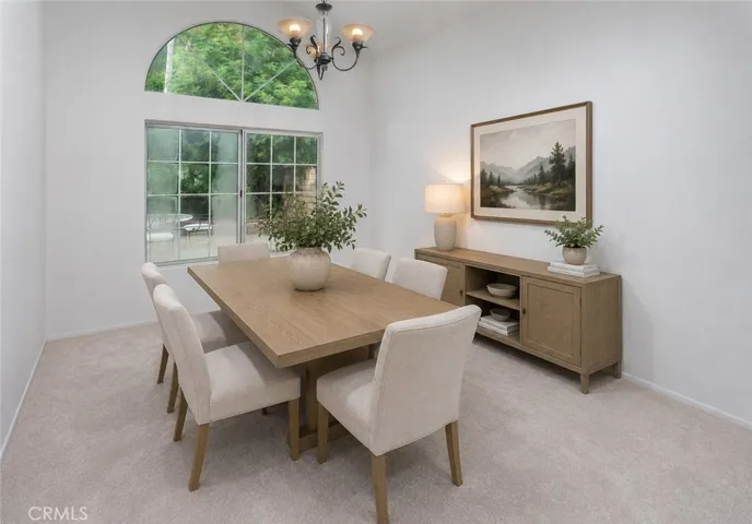 Virtually Staged
Just off the kitchen, the dining room adds warmth with sunburst fanlight window detailing and chandelier lighting.