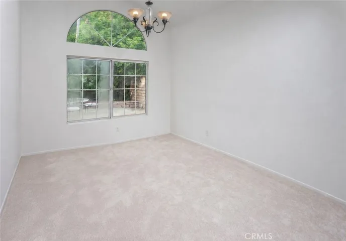 Just off the kitchen, the dining room adds warmth with sunburst fanlight window detailing and chandelier lighting.