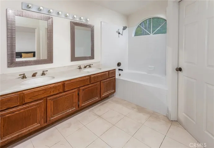En suite primary bath with dual sinks, soaking tub and shower combination, bidet, and privacy area.