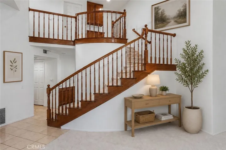 Virtually Staged
Inside, soaring cathedral ceilings, a dramatic sweeping staircase, and natural light pouring through mullioned windows create an open, airy feel.