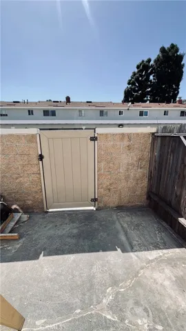 Sunny back patio with gate to the parking area.