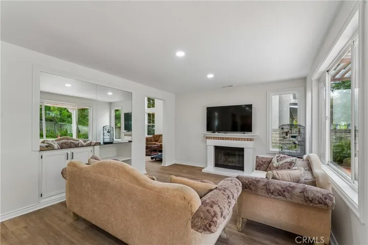 Family room with a cozy fireplace and a direct, scenic view of the backyard.