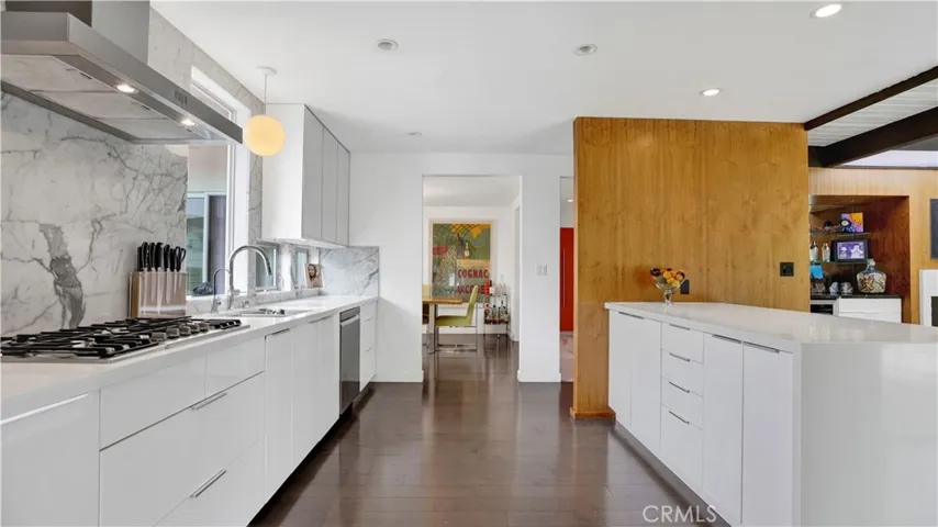 Chef’s kitchen boasts stone countertops, stainless steel appliances, and lacquered glass cabinetry.