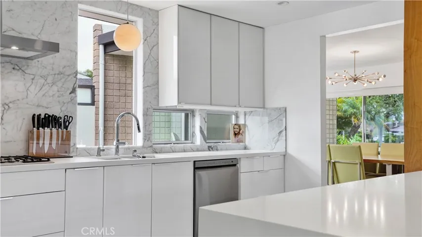 Chef’s kitchen boasts stone countertops, stainless steel appliances, and lacquered glass cabinetry.