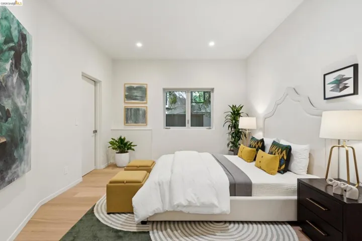 Bright bedroom featuring light wood-finish flooring and white walls