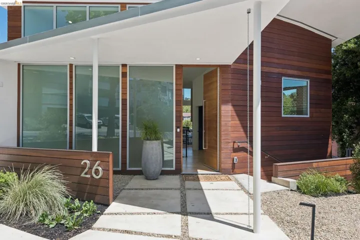 Modern architectural exterior featuring wood-finish siding and an angular white overhang