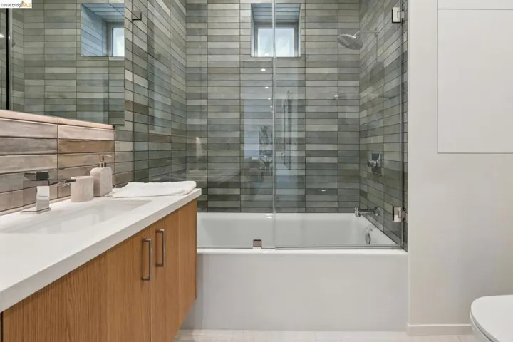 Bathroom featuring a wood-finish floating vanity with a white countertop and rectangular undermount sink
