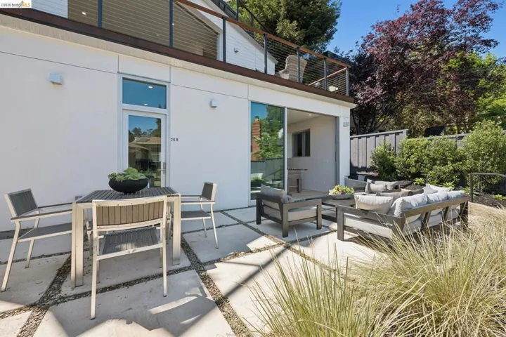 Patio area featuring large format concrete pavers with gravel accents, a sliding glass door, and a full-light exterior door