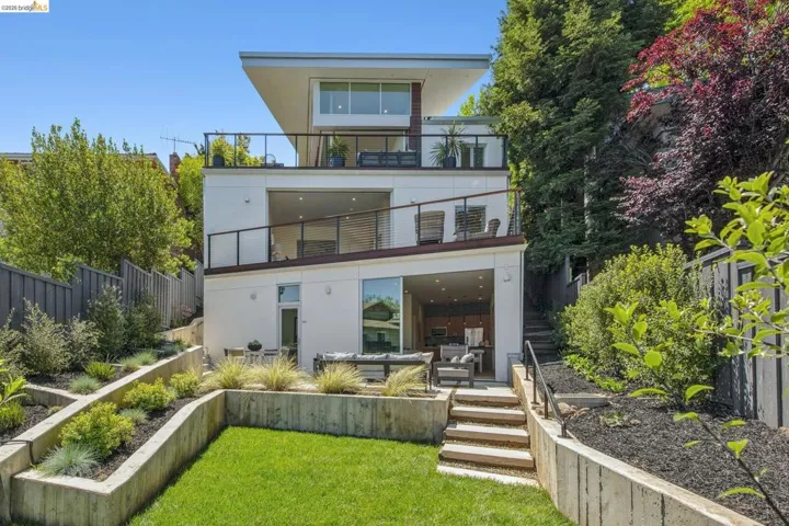 Multi-level contemporary residence featuring three distinct outdoor terraces with glass railings