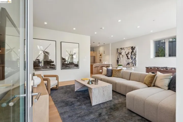 Open concept living area featuring light wood-finish flooring, recessed lighting, and a large window