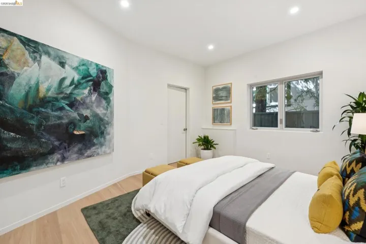 Bright room featuring light wood-finish flooring, recessed lighting, and a white paneled door