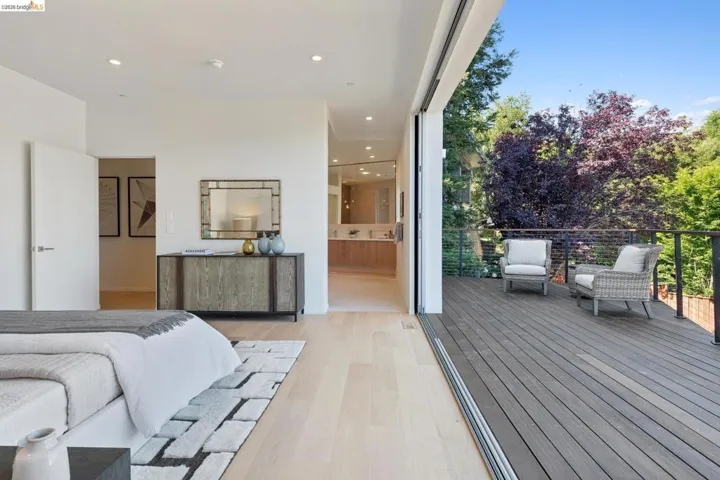 Expansive outdoor deck with cable railings and mature tree backdrop