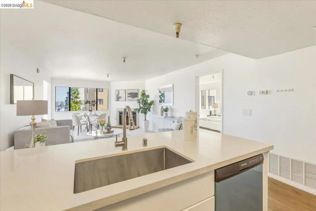 Kitchen island with an undermount stainless steel sink, pull-down faucet, and light-toned solid surface countertop Kitchen island with an undermount stainless steel sink, pull-down faucet, and light-toned solid surface countertop