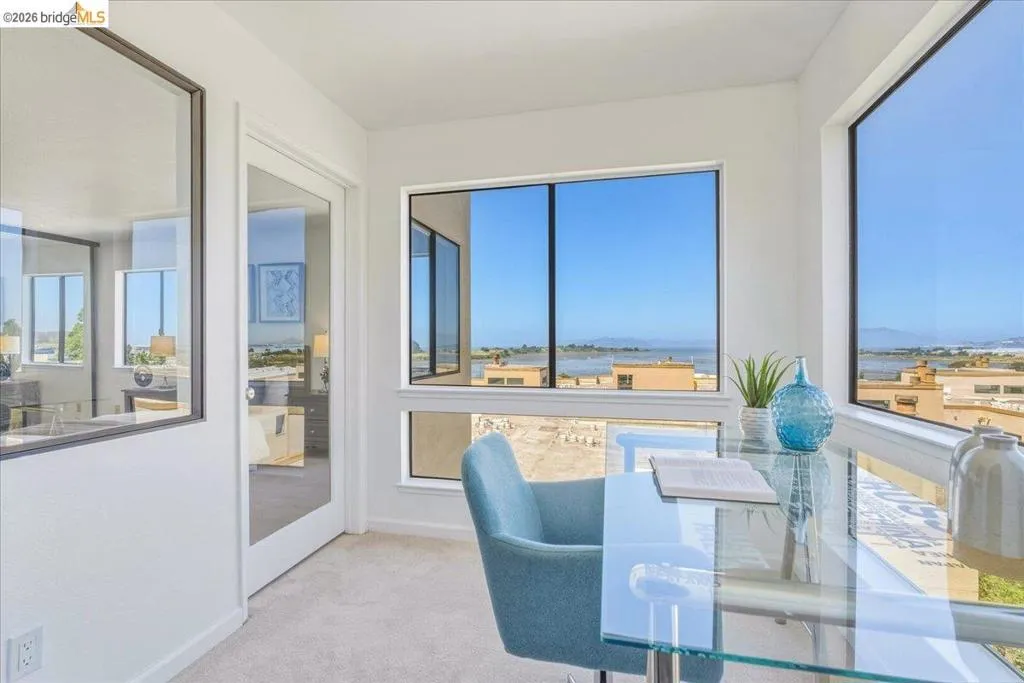 Bright flex space featuring expansive windows, carpeted flooring, a glass panel door, and a built-in window ledge Bright flex space featuring expansive windows, carpeted flooring, a glass panel door, and a built-in window ledge