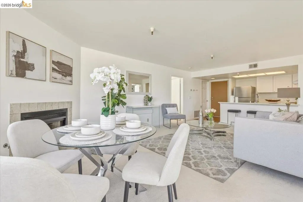 Living area featuring a fireplace with a light tile surround, a built-in breakfast bar, and recessed lighting Living area featuring a fireplace with a light tile surround, a built-in breakfast bar, and recessed lighting