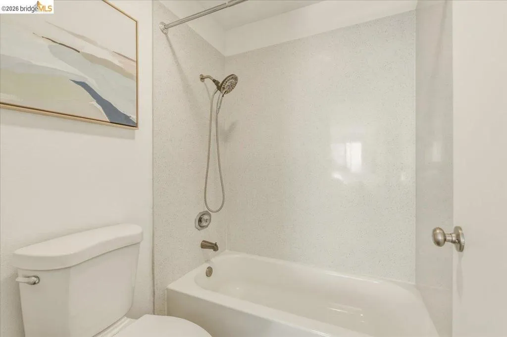 White porcelain bathtub and shower combination featuring a brushed nickel shower head and faucet set White porcelain bathtub and shower combination featuring a brushed nickel shower head and faucet set