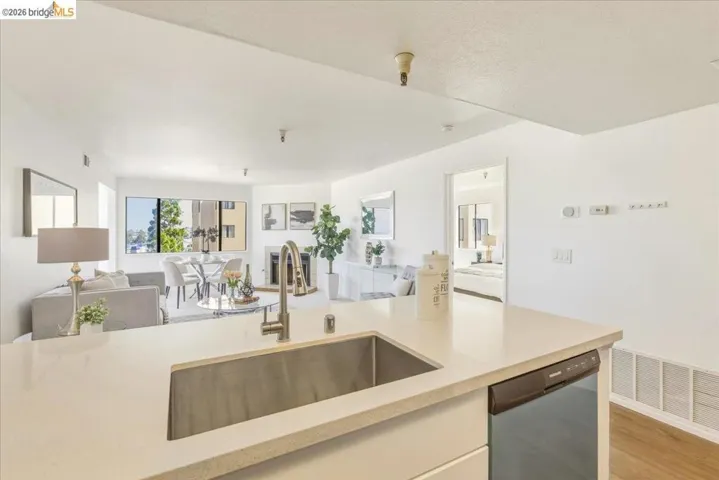 Kitchen island with an undermount stainless steel sink, pull-down faucet, and light-toned solid surface countertop
