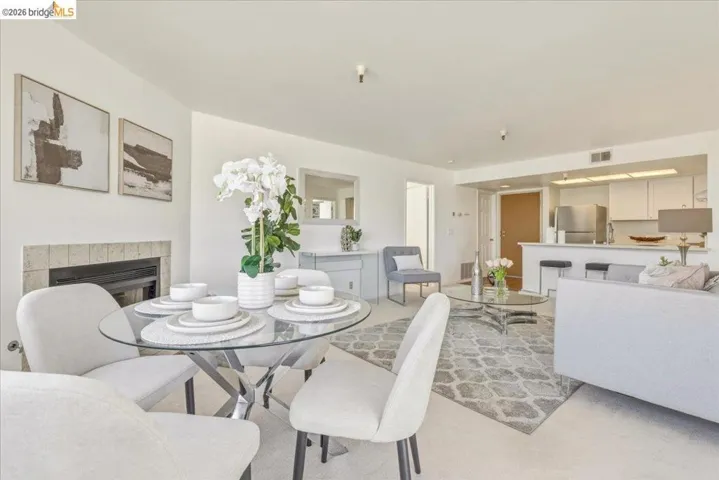 Living area featuring a fireplace with a light tile surround, a built-in breakfast bar, and recessed lighting