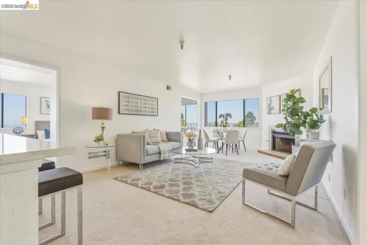 Living area featuring carpet flooring, a fireplace, and multiple windows