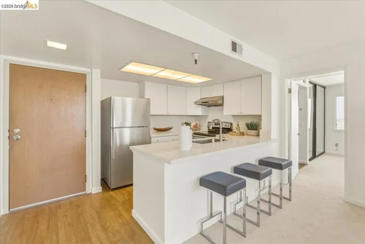 Kitchen featuring white cabinetry, stainless steel appliances, a breakfast bar, and recessed lighting