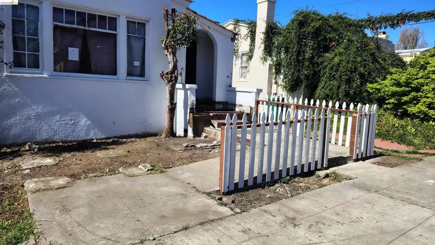 White picket fence enclosing a small front yard area