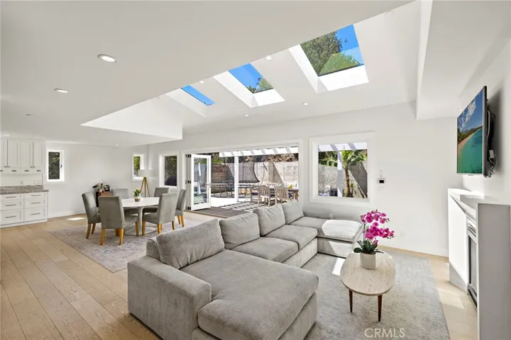 The open-concept layout transitions from the living room to the dining area and into a chef’s kitchen.