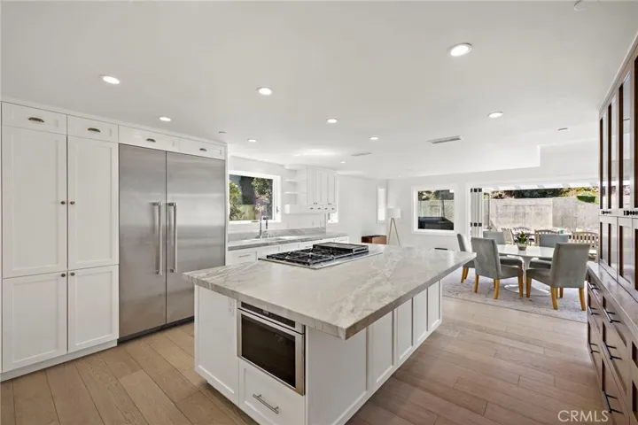 Chef’s kitchen complete with quartz countertops, an expansive island with breakfast bar seating, a high-end appliance package, and beautiful custom built-ins.