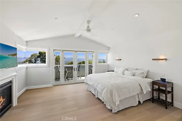  The primary suite is a true retreat, highlighted by vaulted ceilings, a fireplace, private balcony, and picture windows that frame sweeping mountain views.