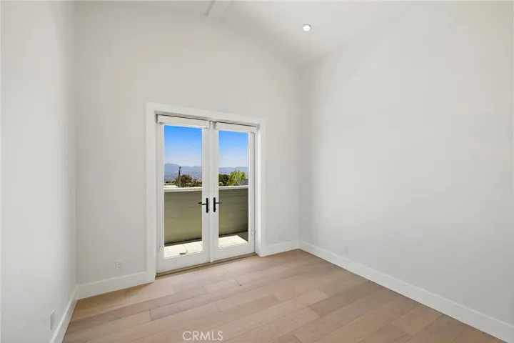 Upstairs guest bedroom with vaulted ceilings and private balcony