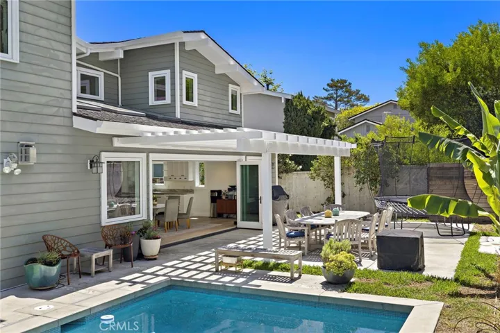 A covered patio offers generous space for gatherings, while a saltwater pool and spa complete the outdoor setting