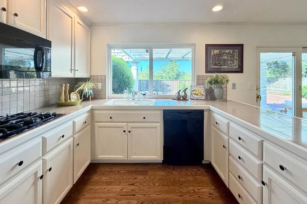 Bright kitchen with breakfast bar seating and built-in appliances.