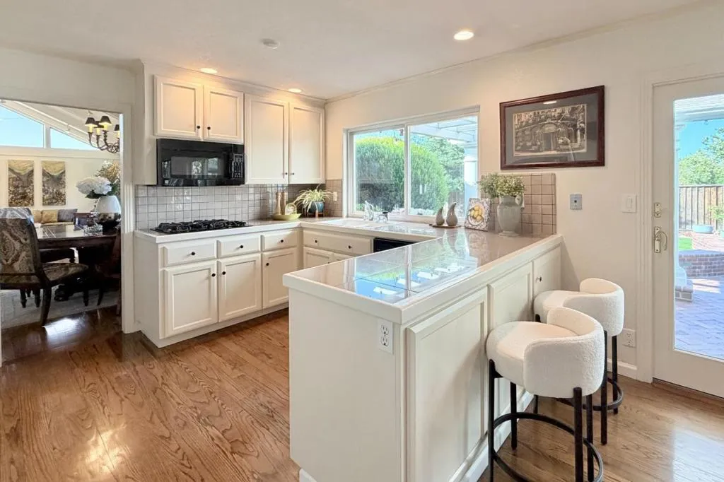 Bright kitchen with breakfast bar seating and built-in appliances.