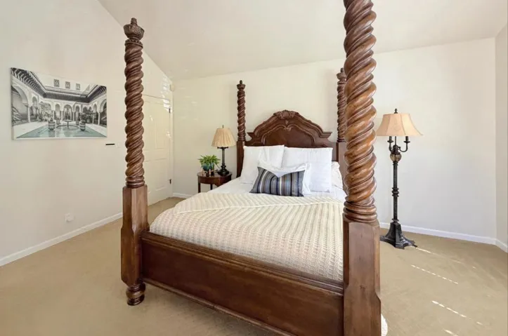 Primary bedroom with vaulted ceiling and natural light.