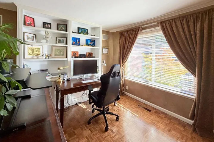 Home office with built-in shelving and natural light.